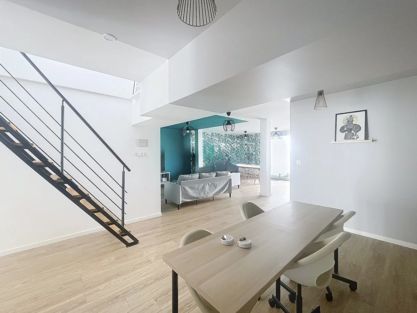 Espace repas de la maison avec grande table et escalier