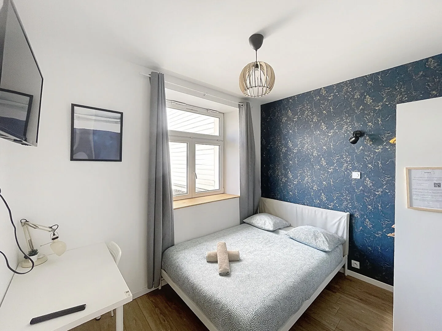 Chambre en suite avec bureau et téléviseur mural